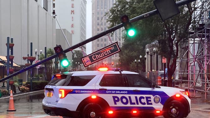 A police vehicle blocks an intersection where a traffic signal pole snapped n the downtown business area after Hurricane Milton passed through on October 10, 2024 in Orlando, Florida.