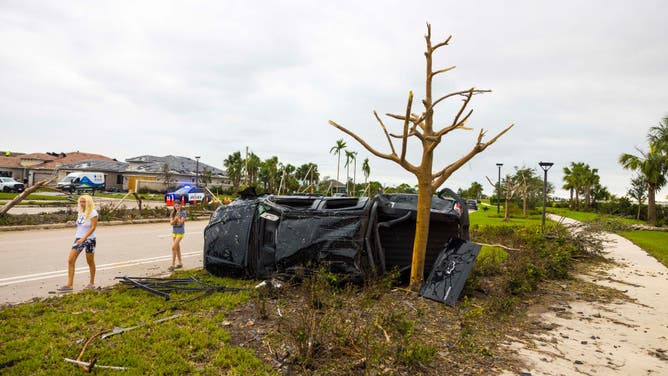 A car flipped onto its side is seen on October 10, 2024 in Palm Beach Gardens, Florida.