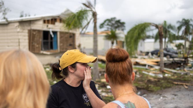 LAKEWOOD PARK, FLORIDA- OCTOBER 11 Tracy Carter, left, of Lakewood Park, and her daughters Savannah Rath, middle, of Palm Bay, and Summer Capito, of Vero Beach react to seeing Tracy's home which had been destoryed by a tornado spawned in the outter bands of Hurricane Milton at Spanish Lakes Country Club Village in Lakewood Park, Florida on October 11, 2024. The family traveled back to the house to gather clothes and other salvagable items. (Photo by Kathleen Flynn for the Washington Post)