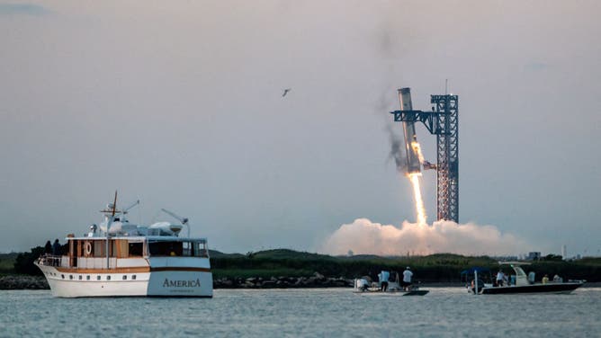 Starship's Super Heavy Booster is grappled at the launch pad in Starbase near Boca Chica, Texas, on October 13, 2024, during the Starship Flight 5 test. SpaceX successfully "caught" the first-stage booster of its Starship megarocket Sunday as it returned to the launch pad after a test flight, a world first in the company's quest for rapid reusability. (Photo by SERGIO FLORES / AFP)