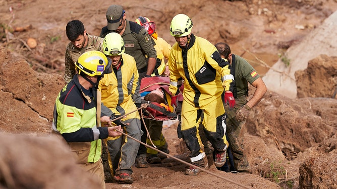 Emergency workers carry an injured person after flash floods hit the region on October 30, 2024 in Letur, Albacete province, Spain.