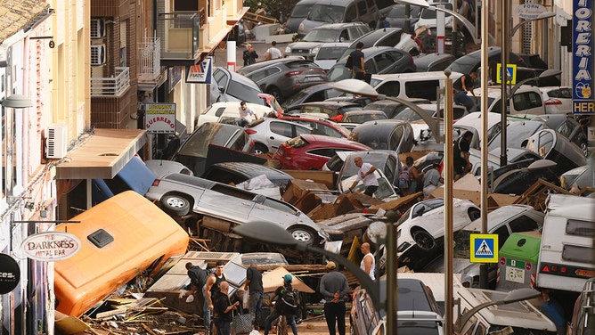 2024年10月30日、スペイン・バレンシアのセダヴィ地区で洪水が発生し、他の瓦礫とともに車が路上に積み上げられた。