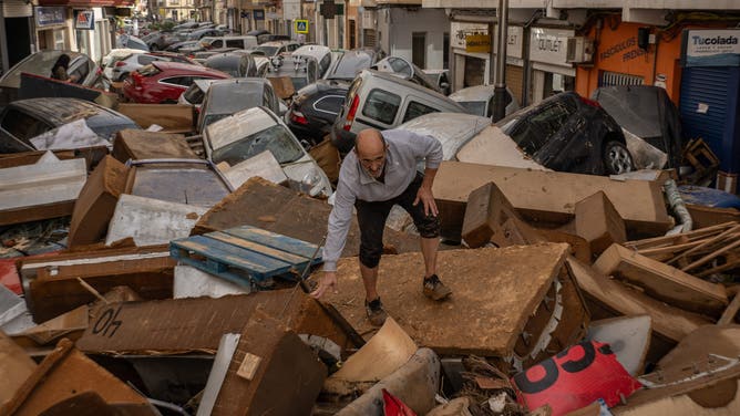 UTIEL, SPAIN - OCTOBER 30: A man walks through a debris-covered street after flash floods hit the region on October 30, 2024 in the Sedaví area of Valencia, Spain. Spanish authorities said on Wednesday that at least 62 people had died in the Valencia region overnight after flash-flooding followed heavy rain. Spain's meteorological agency had issued its highest alert for the region due to extreme rainfall.