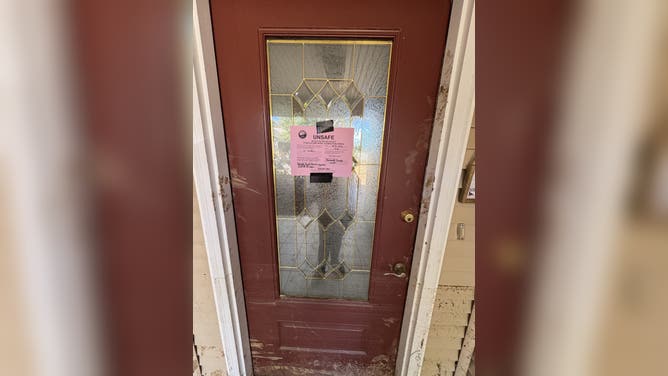 A sign marking Cindy Riley's home unsafe after flooding.