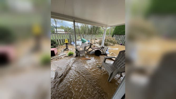 Floodwaters and debris litter the Riley family's yard after Helene.