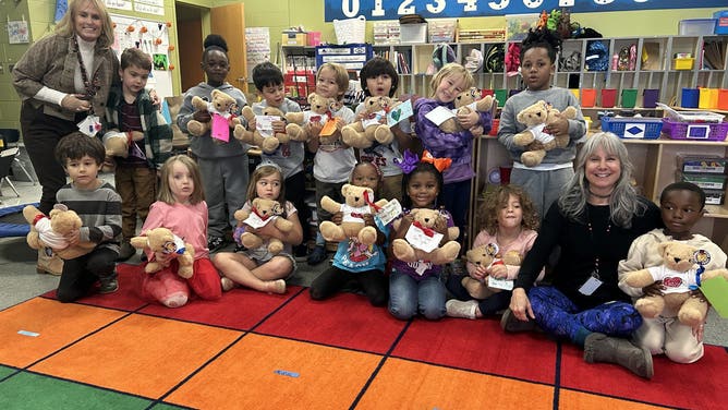 Students hold their teddy bears.