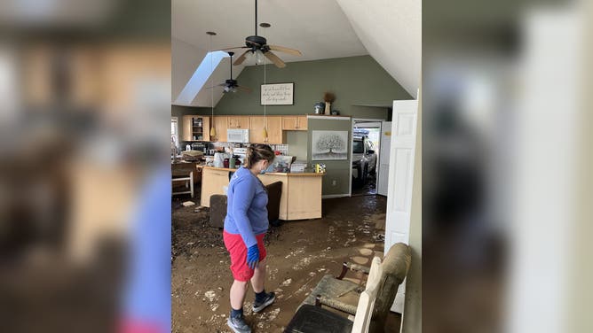 Mud and debris from floodwaters fill the Riley family's home.
