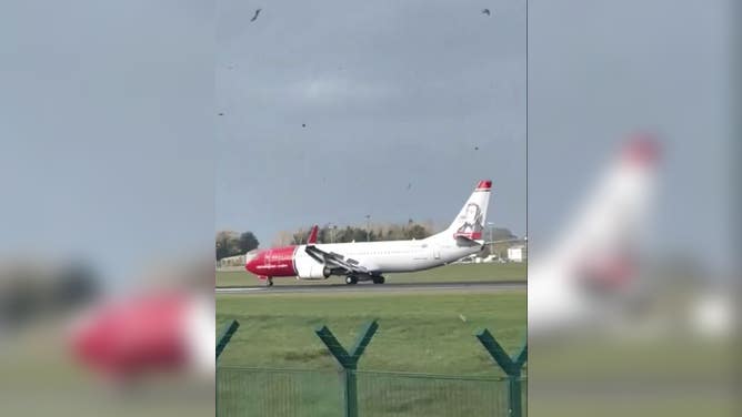 Norwegian plane taxiis across runway at Dublin Airport after tricky landing. 