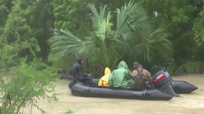 This image shows people on a boat during flooding caused by Tropical Storm Oscar in Cuba.