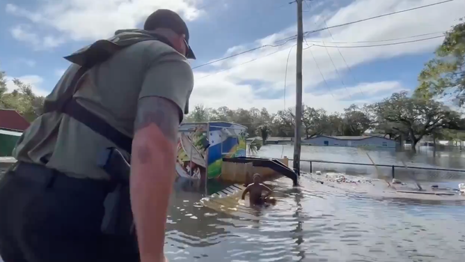 The sheriff sees the boy floating on the debris.