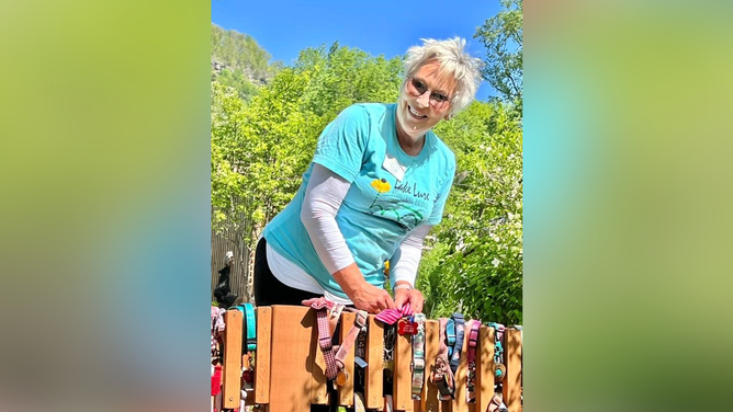 Reandeau puts on a dog collar on the Rainbow Bridge for a visitor who recently lost his dog.