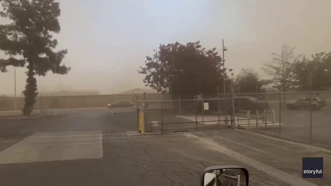 A car drives through a dust storm in Tulare, California.