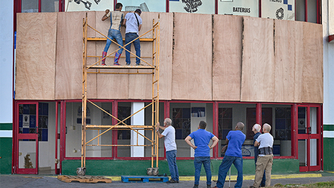 Workers protect a facility ahead of the arrival of Tropical Storm Rafael in Havana on November 5, 2024. Cuba was preparing for Tropical Storm Rafael, which is expected to make landfall on the island as a hurricane on November 6, adding to the misery caused by a massive blackout and Hurricane Oscar. (Photo by ADALBERTO ROQUE/AFP) (Photo by ADALBERTO ROQUE/AFP via Getty Images)