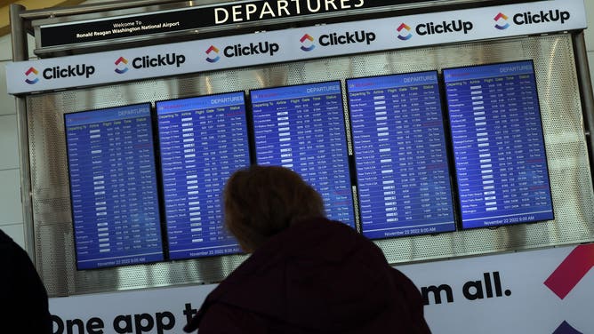 A passengers looks at a departure schedule at Ronald Reagan Washington National Airport on November 22, 2022 in Arlington, Virginia.