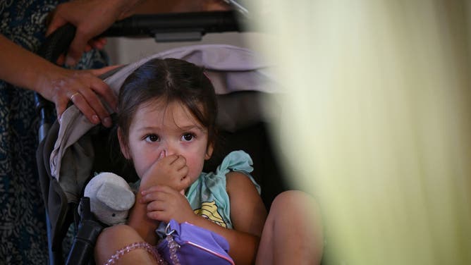 A child holds her nose while viewing the Corpse Flower during it's brief bloom, as it is displayed at the Botanical Gardens section of the Huntington Library in San Marino, California, on August 28, 2023.