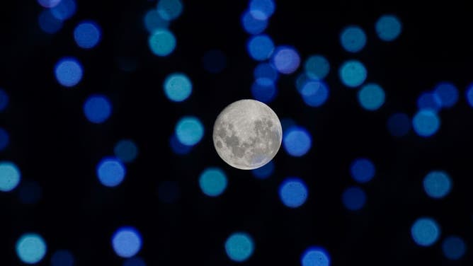 The Beaver Moon is seen through the Christmas lights from the historic center on November 28, 2023 in San Salvador, El Salvador.