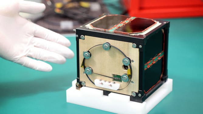 The world's first wooden satellite made from wood and named LignoSat, developed by scientists at Kyoto University and logging company Sumitomo Forestry, is shown during a press conference at Kyoto University in Kyoto on May 28, 2024.