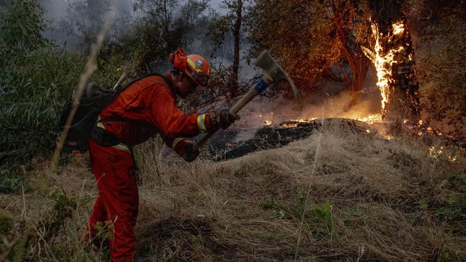 An incarcerated firefighter with the California Department of Corrections and Rehabilitation Antelope Conservation Camp Crew 4 constructs a hand line while battling the Thompson Fire in Oroville, Calif., Tuesday, July 2, 2024.