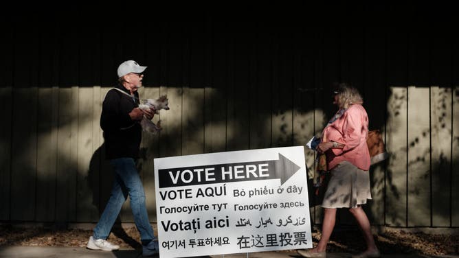 A couple meets after voting at an early voting polling station in Black Mountain, North Carolina, on October 29, 2024, a month after Hurricane Helene struck the area.