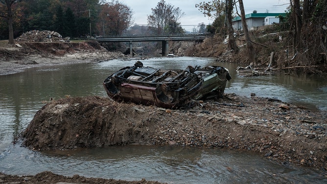 Destroyed cars remain in a river after the flooding caused by Hurricane Helene about a month ago in Asheville, North Carolina, on October 30, 2024.