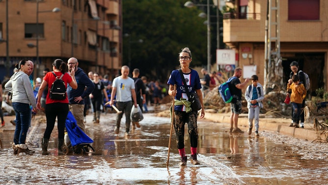 2024年11月1日、スペイン東部バレンシア地方のパイポルタの町で洪水による壊滅的な被害が発生した後、ぬかるんだ道を歩く女性。