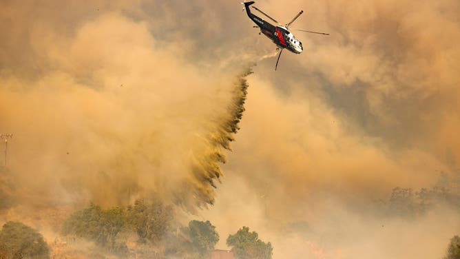 A firefighting helicopter makes drop over the Mountain Fire in Camarillo Heights, Camarillo, California, on November 6, 2024.