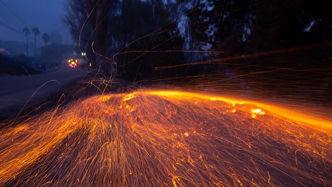 Ember flies near a burned home on Vista del Mar during a wind-driven fire in Santa Ana on Wednesday, November 6, 2024 in Camarillo, CA.