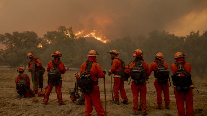 Incarcerated firefighters with the California Department of Corrections and Rehabilitation (CDCR) Fenner Canyon Conservation Camp take a break while battling the Mountain Fire in Moorpark, Calif., on Thursday, Nov. 7, 2024.