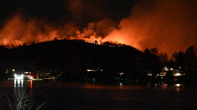 Smoke and flames rise as wildfire burns and spreads on a mountain in West Milford, New Jersey, United States on November 9, 2024. 