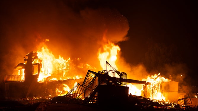 Flames engulf a structure during a fast-moving wildfire on November 6, 2024 in Moorpark, California.