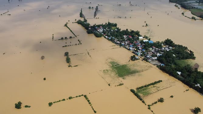 航空写真には、台風トラジャが同州を襲った翌日、2024年11月12日にイサベラ州イラガン町の村で、増水した川が農家の田畑や家々に浸水している様子が写っている。