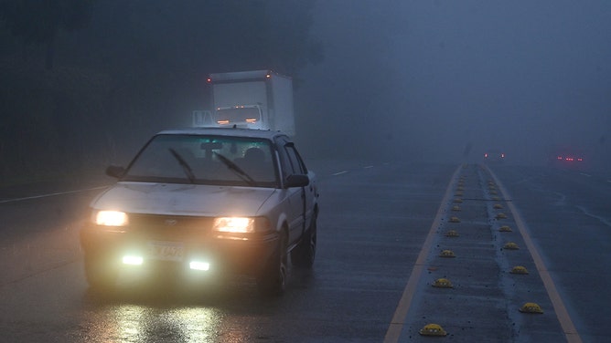 A car drives through heavy fog ahead of the arrival of tropical storm Sara in Siguatepeque, Honduras on November 14, 2024.