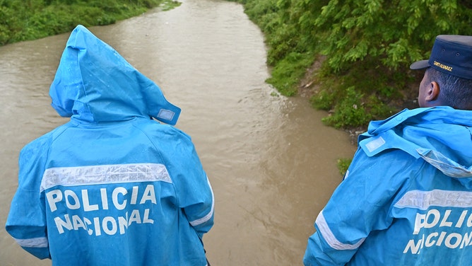 Members of the National Police monitor the level of rivers that have risen due to the rains in Choloma, Honduras, on November 15, 2024.