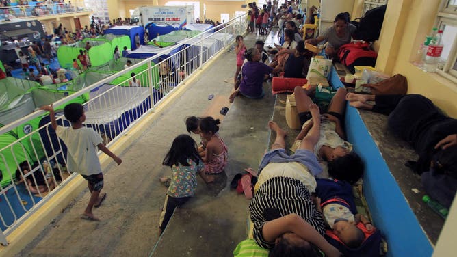 People rest at an evacuation centre for those affected by Super Typhoon Man-yi in San Vicente town, Camarines sur province on November 17, 2024. Super Typhoon Man-yi slammed into the Philippines' most populous island on November 17, with the national weather service warning of flooding, landslides and huge waves as the storm sweeps across the archipelago nation.