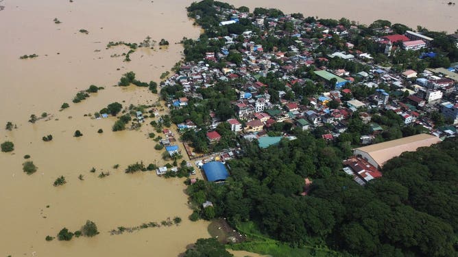 2024年11月18日、超大型台風マグニーによる継続的な大雨により、イサベラ州イラガンの村で浸水した家々を示す航空写真。フィリピンを襲ったこの1か月で6回目となる大型ハリケーンにより、脆弱な建物が破壊され、停電し、少なくとも8人の命が失われた後、フィリピン人は11月18日、倒木を撤去し、損傷した家屋を修復した。