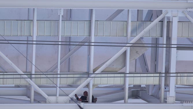 ARLINGTON, TEXAS - NOVEMBER 18: A worker secures a metal sheet prior to an NFL football game between the Dallas Cowboys and the Houston Texans at AT&T Stadium on November 18, 2024 in Arlington, Texas.