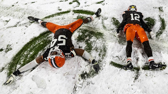 Ogbo Okoronkwo #54 of the Cleveland Browns and Rodney McLeod Jr. #12 make snow angels after the game against the Pittsburgh Steelers at Huntington Bank Field on November 21, 2024 in Cleveland, Ohio.