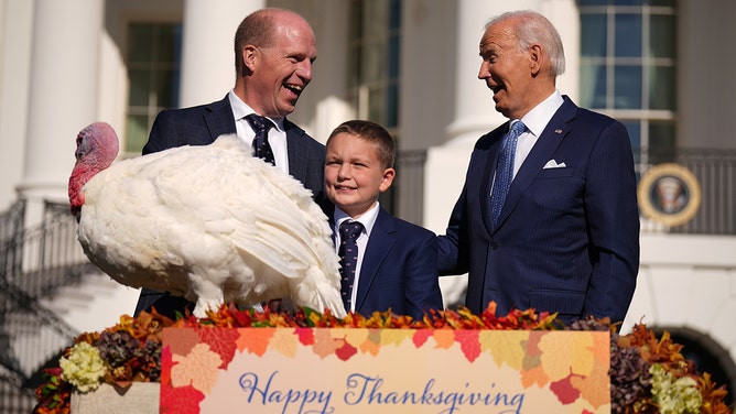 President Joe Biden (R) pardons the National Thanksgiving Turkey Peach, alongside Chair of the national turkey federation John Zimmerman and his son Grant during a ceremony on the South Lawn of the White House on November 25, 2024 in Washington, DC.