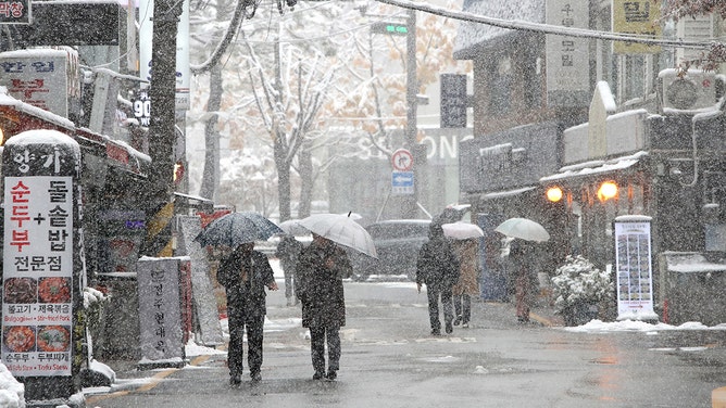Pedestrians walk along a street on November 27, 2024 in Seoul, South Korea.