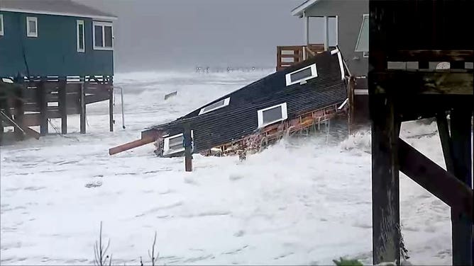 The debris left by a home collapse sloshes in the surf in Rodanthe, North Carolina, on Nov. 15, 2024.