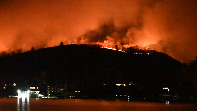 WEST MILFORD, NEW JERSEY, UNITED STATES - NOVEMBER 9: Smoke and flames rise as wildfire burns and spreads on a mountain in West Milford, New Jersey, United States on November 9, 2024. Large flames have overtaken the mountain and more than 2000 acres have burned. (Photo by Kyle Mazza/Anadolu via Getty Images)