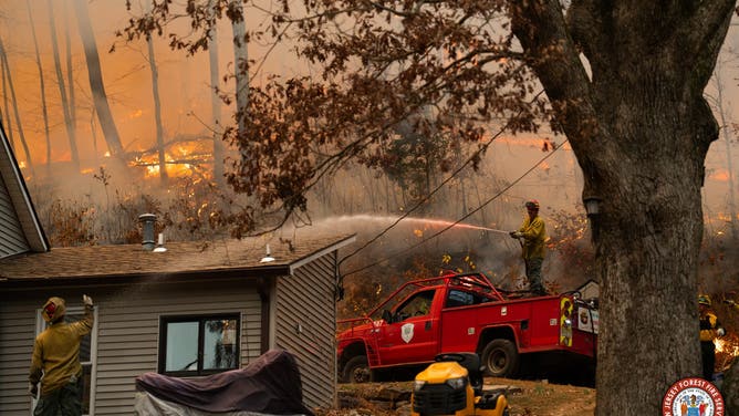 Photos show flames from the Craigmeur Lookout Wildfire in Rockaway, New Jersey close to a home.