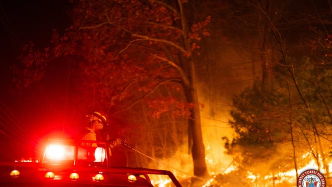 Photos show flames from the Craigmeur Lookout Wildfire in Rockaway, New Jersey close to a home.
