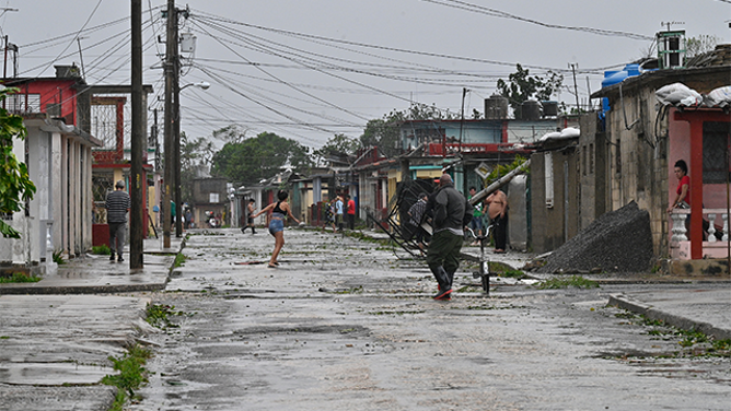 People walk on the streets during the pass of the Hurricane Rafael's eye in Pueblo Candelaria, Artemisa Province, 65 km west of Havana, on November 6, 2024. Hurricane Rafael knocked out power to all of Cuba on Wednesday as it made landfall on the island still reeling from a recent blackout and a previous major storm, the national power company said. (Photo by ADALBERTO ROQUE / AFP) (Photo by ADALBERTO ROQUE/AFP via Getty Images)