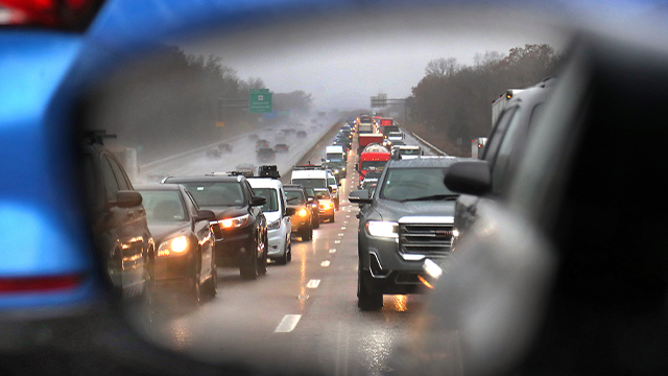 FILE - Traffic came to a standstill on Route 3 northbound in Braintree as seen in a car's rearview mirror after a multi-car accident shut down the 3 travel lanes making it a 38 minute backup. The mass exodus of Thanksgiving travelers began early Wednesday morning. (Photo by John Tlumacki/The Boston Globe via Getty Images)
