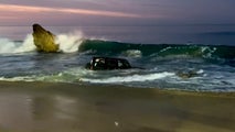 Waves pull Jeep into rough surf as California rescuers work to save driver