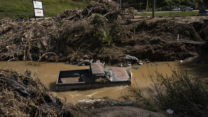 A pick-up truck is seen in a muddy stream in the aftermath of Hurricane Helene in Burnsville, North Carolina, on October 5, 2024. 