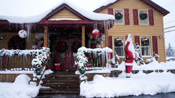 A statue of Santa Claus is covered in snow outside of a realty business on December 4, 2024 in Watertown, New York.