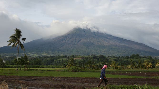 Kanlaon volcano is seen past farmland at a village in La Castellana town, Negros Occidental province on December 10, 2024.