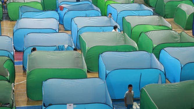 Evacuees are seen by tents erected at a shelter a day after the eruption of Kanlaon volcano in Bago City, Negros Occidental province on December 10, 2024.